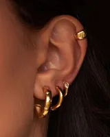 Set de aros dorados con diferentes diseños: un aro liso, un aro con textura, un aro con tres hileras de strass y un cuff liso.