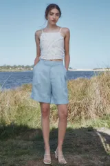 Bermuda celeste de lino de tiro alto, con pliegues debajo de la cintura, piernas anchas con tablas y detalle de botamanga.