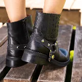 Bota corta negra de cuero vacuno con estribo desmontable, suela de caucho, cierre interno y punta redonda.