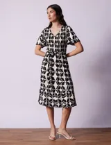 Vestido estampado con escote en V con frunces, cintura elastizada con lazo de ajuste y mangas cortas con detalles en broderie.