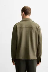 Sobrecamisa color beige de corte recto, con cuello solapa, manga larga con puños abotonados, cierre frontal abotonado, bolsillos de parche con solapa en el pecho y bolsillos de ojal en la cadera.