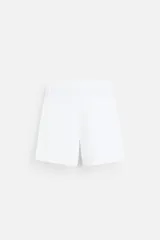Bermuda regular fit negra confeccionada en tejido de lino. Cintura elástica ajustable con cordón y pliegues frontales. Bolsillos frontales y detalle de bolsillos traseros de plastrón.