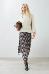 Sweater beige claro de tejido de punto con cuello redondo y mangas largas con flecos.