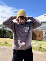 Canguro marrón con capucha y estampado blanco en la espalda con la frase "Talk Less Smile More".
