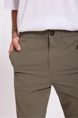Pantalón de vestir azul marino, de corte recto, con bolsillos laterales y traseros. Se ajusta a la cintura con cinturón de cuero marrón.