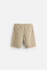 Bermuda color beige de denim de algodón, corte relaxed fit, con cintura elástica ajustable con cordón, bolsillos frontales y traseros.