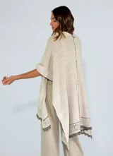 Ruana color crudo de tejido de punto calado con terminaciones en crochet.