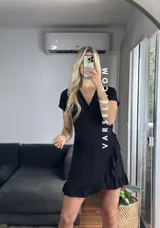 Vestido corto rojo con escote cruzado, mangas cortas y falda con volados. Se ajusta con lazo lateral tipo pareo.