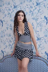 Minifalda negra con lunares blancos, pretina elastizada a rayas blancas y negras, confeccionada en lycra y modal.