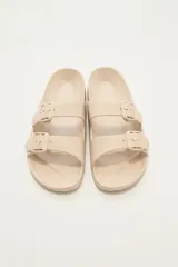 Sandalias tipo Birkenstock color beige con hebillas ajustables.