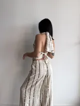 Top halter de mujer color beige con estampado tie-dye vertical en tonos marrones. El corpiño es corto y se ata en la espalda y el cuello.