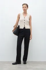 Pantalón de vestir de corte recto y tiro medio, con cierre frontal y bolsillos laterales. Diseño minimalista y versátil.