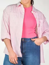 Camisa celeste de calce holgado, manga larga con puño ancho y doble botón, doble bolsillo plastrón en delantero y tajos laterales.