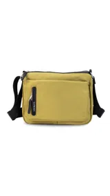 Bandolera color beige de nylon, con correa larga negra regulable. Tiene un bolsillo delantero con tapa, dos bolsillos internos (uno con cierre) y un bolsillo trasero.