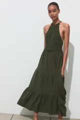 Vestido largo verde con estampado a cuadros, cuello halter con nido de abeja elástico y tirantes trenzados con abalorios.