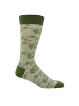 Calcetines largos color beige con diseño de montañas y árboles en verde. El puño, talón y puntera son de color verde oscuro.