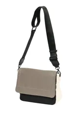 Bandolera con correa larga regulable, cuerpo principal color beige con solapa marrón y base negra.