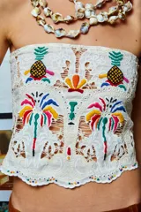 Top strapless color crudo con bordados de palmeras y ananás de colores.