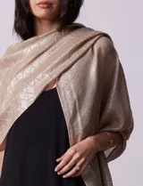 Pashmina color beige de gasa plisada con detalles de lurex plateado y flecos.
