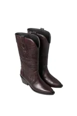 Bota de caña media estilo cowboy, color marrón oscuro con efecto envejecido. Presenta bordados florales en relieve en la caña y puntera afilada. Posee un tacón ancho y bajo.