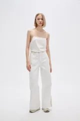 Pantalón jean de calce ancho y tiro alto, con diseño color block en tonos blanco y beige.