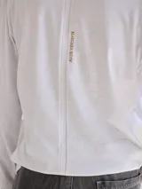 Remera blanca de algodón con escote redondo, mangas largas y pespuntes verticales a contratono.