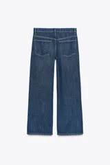 Pantalón de jean azul oscuro, de corte wide leg y tiro medio, con cinco bolsillos y cierre frontal con cremallera y botón metálico.