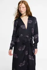 Vestido largo estilo camisero confeccionado en seda viscosa color negro con estampado de tigres en color rosa. Tiene cuello camisero, mangas largas, corte cruzado y lazo en la cintura.
