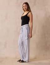 Pantalón cargo de lino color blanco, marca Marissa Olivia. Tiene pretina ancha elastizada con lazo de ajuste, bolsillos inclinados delanteros y bolsillos laterales con botón.