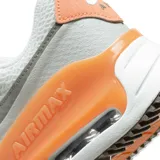 Championes Nike Air Max Systm de mujer, color blanco con detalles en gris y celeste. Capellada de malla y superposiciones de cuero sintético, amortiguación Air Max visible y suela de goma.