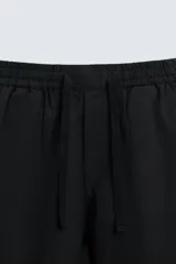 Pantalón azul marino de corte recto, con cintura elástica ajustable con cordón, bolsillos laterales y traseros.