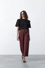 Remera negra de algodón con cuello redondo y mangas cortas con volados en capas.