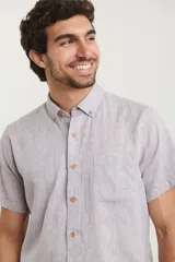 Camisa celeste de manga corta con cuello abotonado y bolsillo en el pecho.