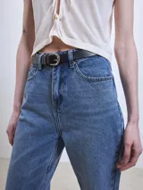 Pantalón de jean gris de corte recto, con bolsillos delanteros y traseros, y presillas para cinturón.