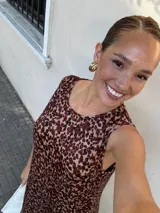 Vestido largo azul marino de tejido acanalado, con escote redondo y mangas cortas tipo hombrera. Presenta una abertura lateral en la falda.