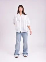 Camisa celeste con cuello mao, corte holgado, mangas 3/4 abullonadas con puños elásticos y cierre frontal con botones.