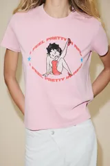 Camiseta rosa de manga corta y cuello redondo con estampado de Betty Boop y texto "I feel pretty in red". Debido al proceso de tintado y lavado, el color de cada prenda es único y especial por lo que puede presentar diferencias con respecto al mostrado en la foto.