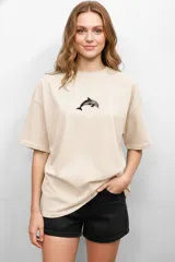 Remera color crema de algodón con estampado de delfín, de corte holgado y cuello redondo.