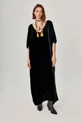 Vestido kaftan largo de terciopelo negro con escote en V y mangas amplias.