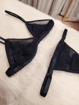 Conjunto de lencería negro de microtul suave y elastizado con detalles de encaje. Incluye corpiño triángulo con breteles finos y tanga regulable de elástico ancho.
