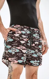 Short de baño negro con estampado de nubes en tonos celeste, rosa y blanco.