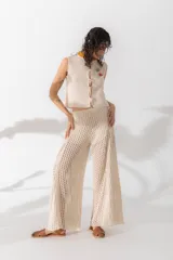 Pantalón tejido de algodón color camel, con diseño de agujeros y pierna ancha.