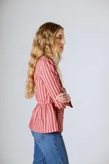 Blusa color rosa con rayas verticales color borgoña, de corte peplum, escote cuadrado y mangas largas abullonadas.