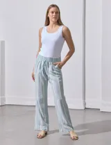 Pantalón de lino con pretina ancha en punto smock con lazo, bolsillos verticales delanteros y bolsillos aplicados traseros.