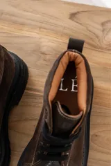 Borcegos negros de cuero charol, con punta cuadrada, cordones y suela track.