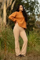 Buzo color naranja con cuello alto y mangas abullonadas.