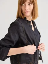 Chaqueta color marrón claro de lino y algodón, con cuello mao, cierre frontal con botones de madera y bolsillos laterales.