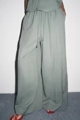 Pantalón de tiro medio con cintura elástica ajustable con cordones, de pierna ancha y bolsillos laterales ocultos en costura. Confeccionado en hilatura con mezcla de lyocell.