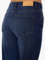 Jean de tiro alto, corte slim flare, en denim de sarga color azul medio con efecto levemente desgastado. Presenta cierre de botón y cremallera.