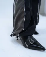 Pantalón deportivo negro con recortes en gris y vivos blancos. Tiro medio, corte holgado, cintura elastizada y cierre en los tobillos.